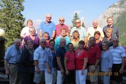 A group of people are posing for a picture in front of a mountain.