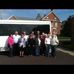 A group of people are posing for a picture in front of a bus.