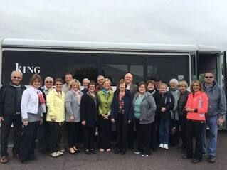 A group of people are posing for a picture in front of a bus.