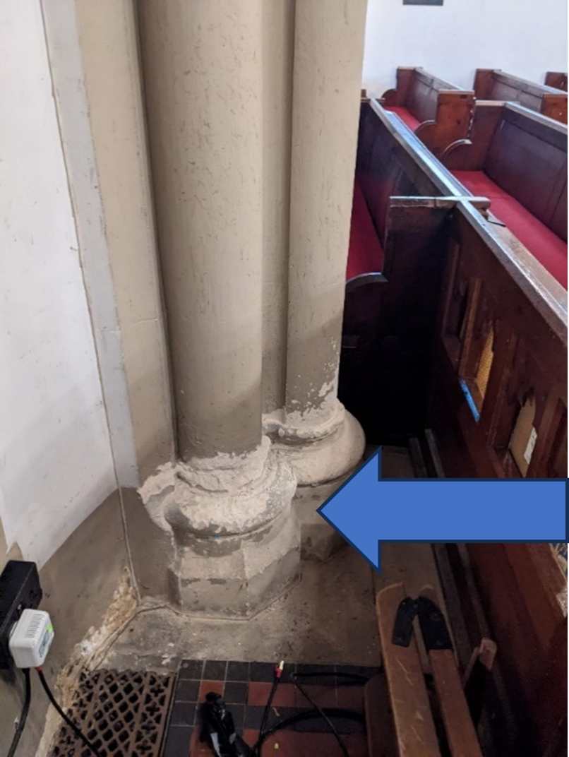 Stone architectural column base in a church, with a blue arrow pointing to it.