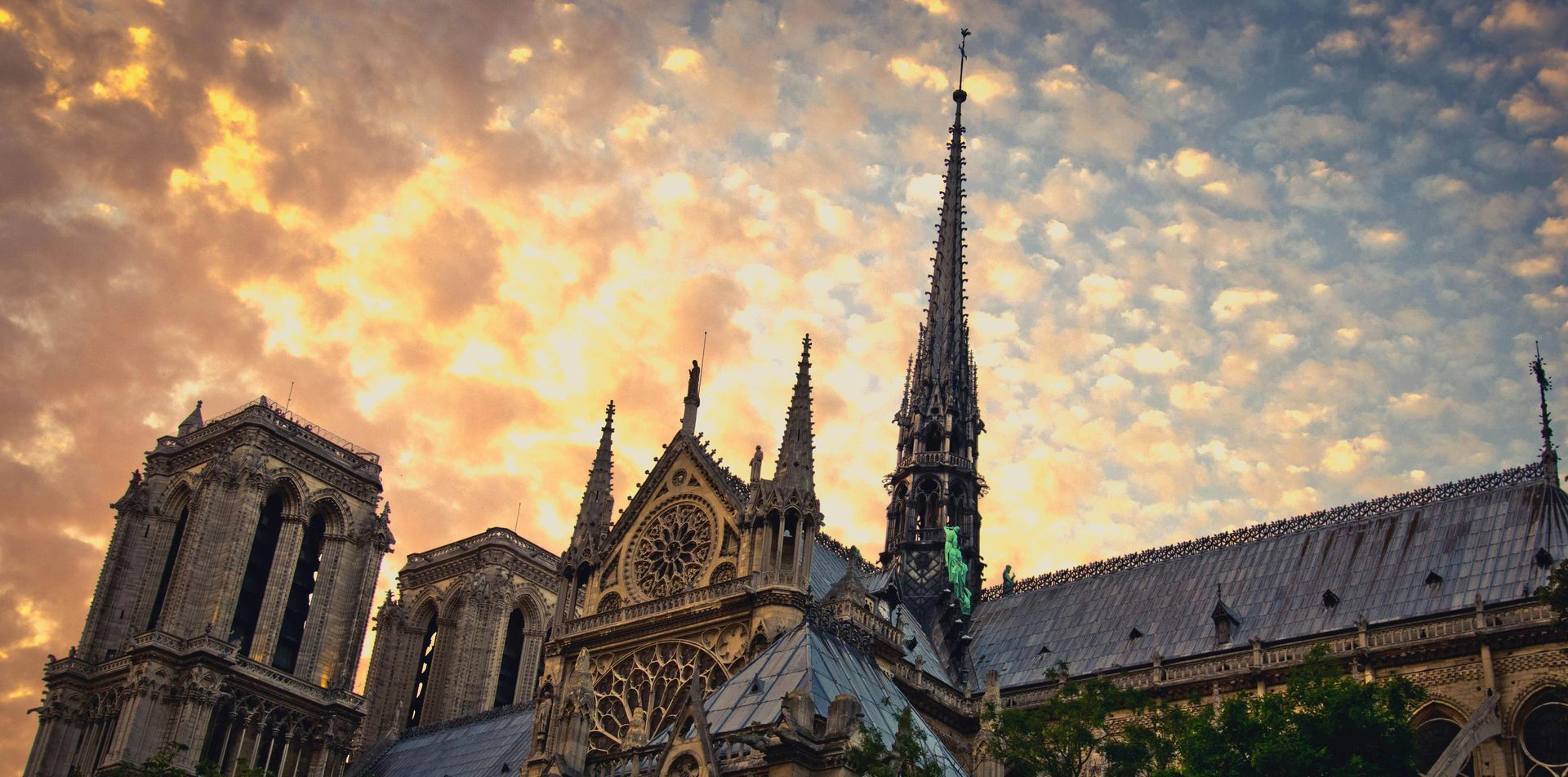 Notre Dame Cathedral, Paris, France, with a dramatic sunset sky.