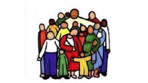 People in a church listen to two men at a table; large cross in window behind them.