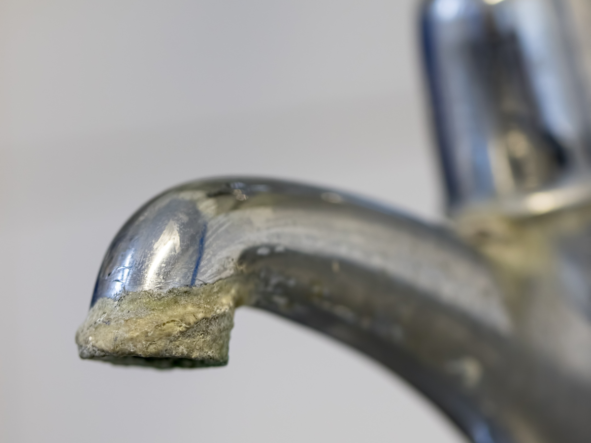 A close up of a faucet with a lot of rust on it.