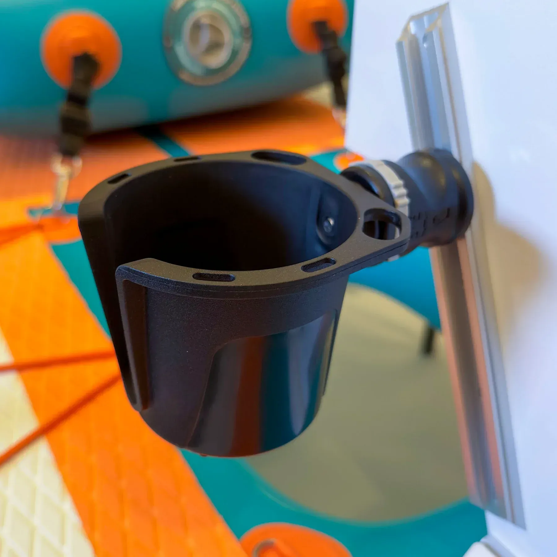 A black cup holder is attached to a wall