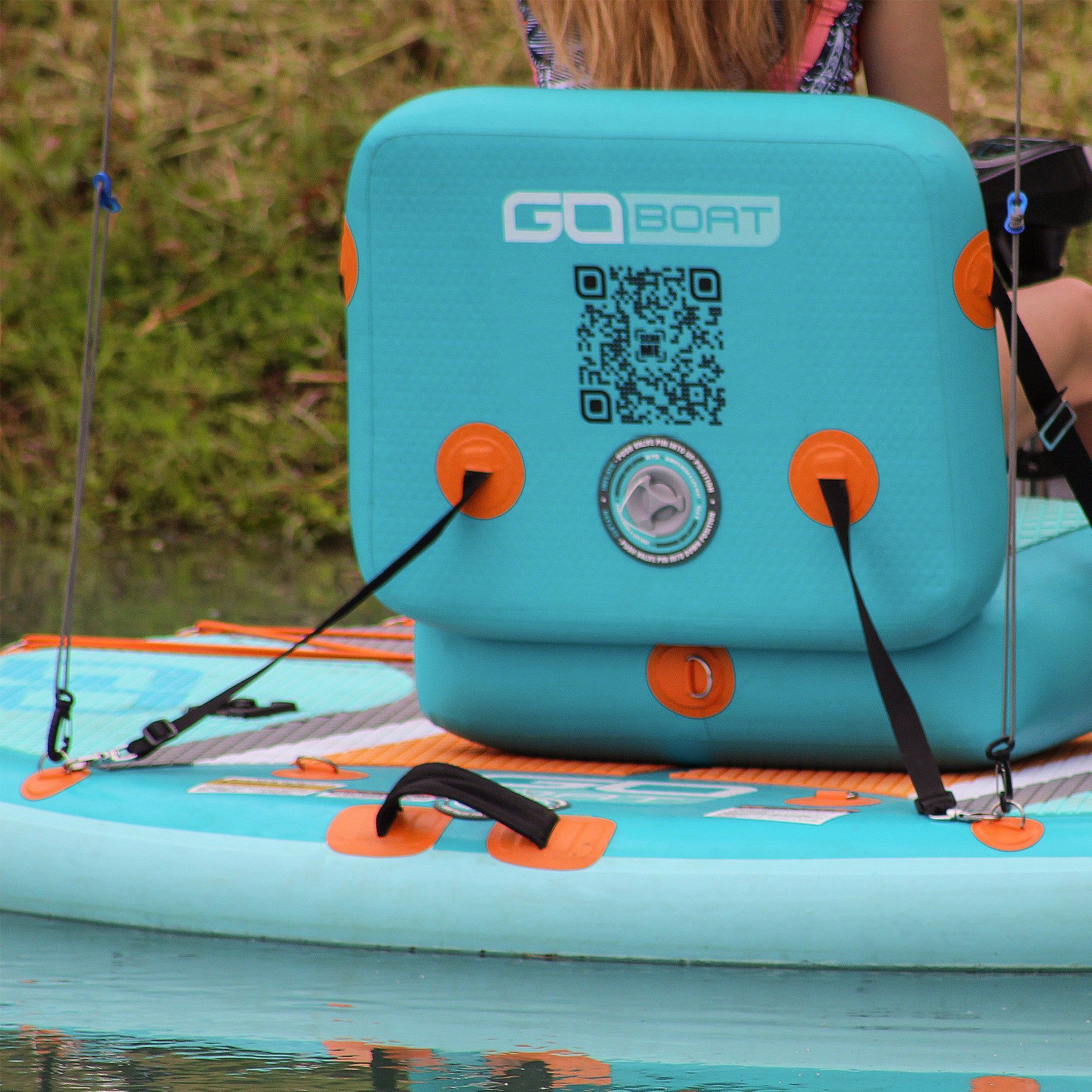 A woman sits on a go boat in the water