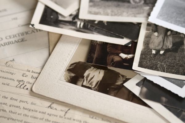 a pile of old photographs and a certificate of marriage