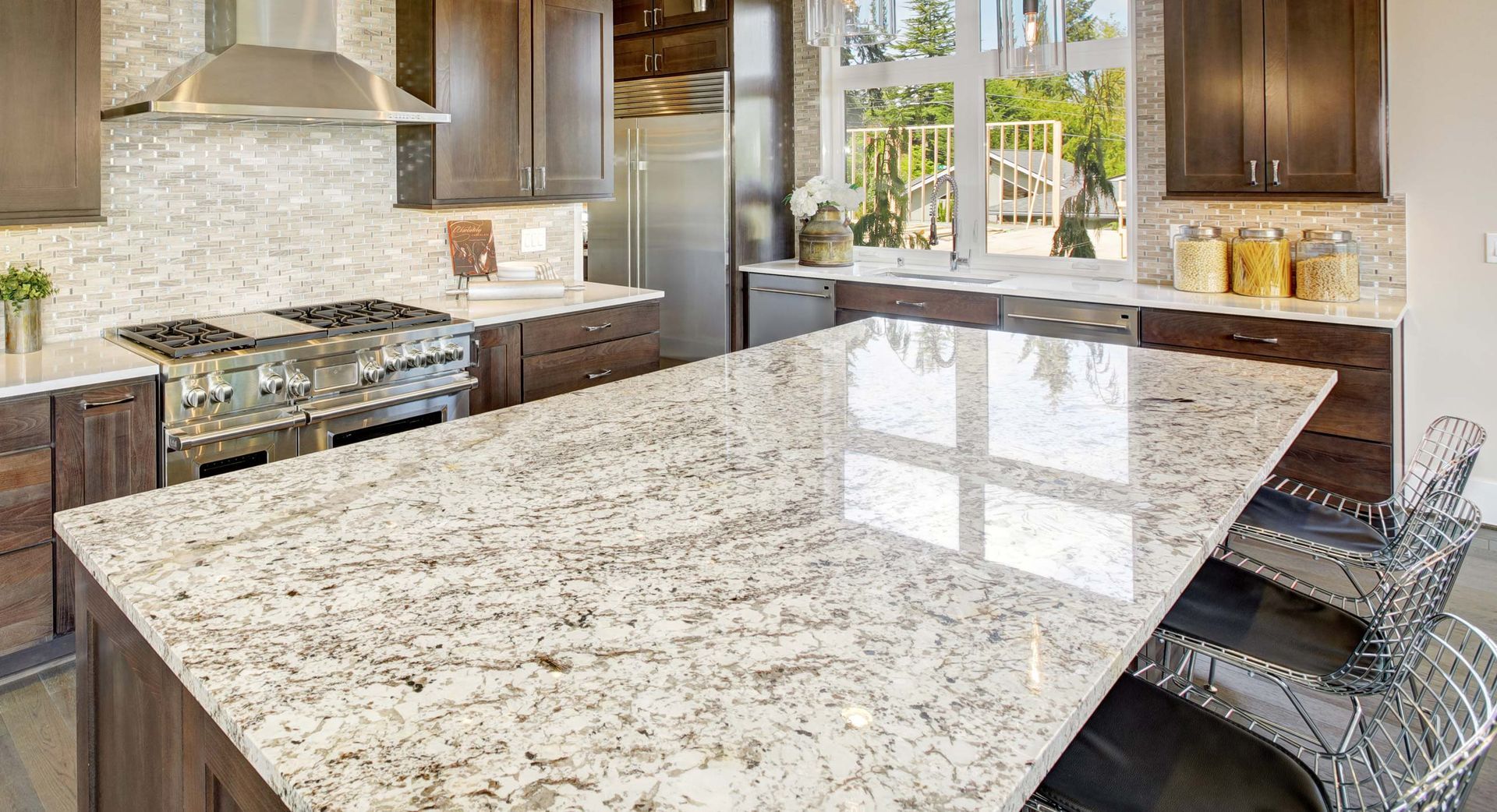 Kitchen with granite countertops, stainless steel appliances, and dark cabinets.