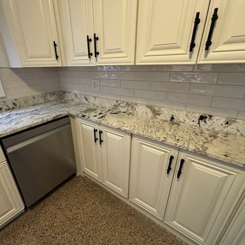 Kitchen with white cabinets, stainless steel appliances, granite countertops, and tile backsplash.