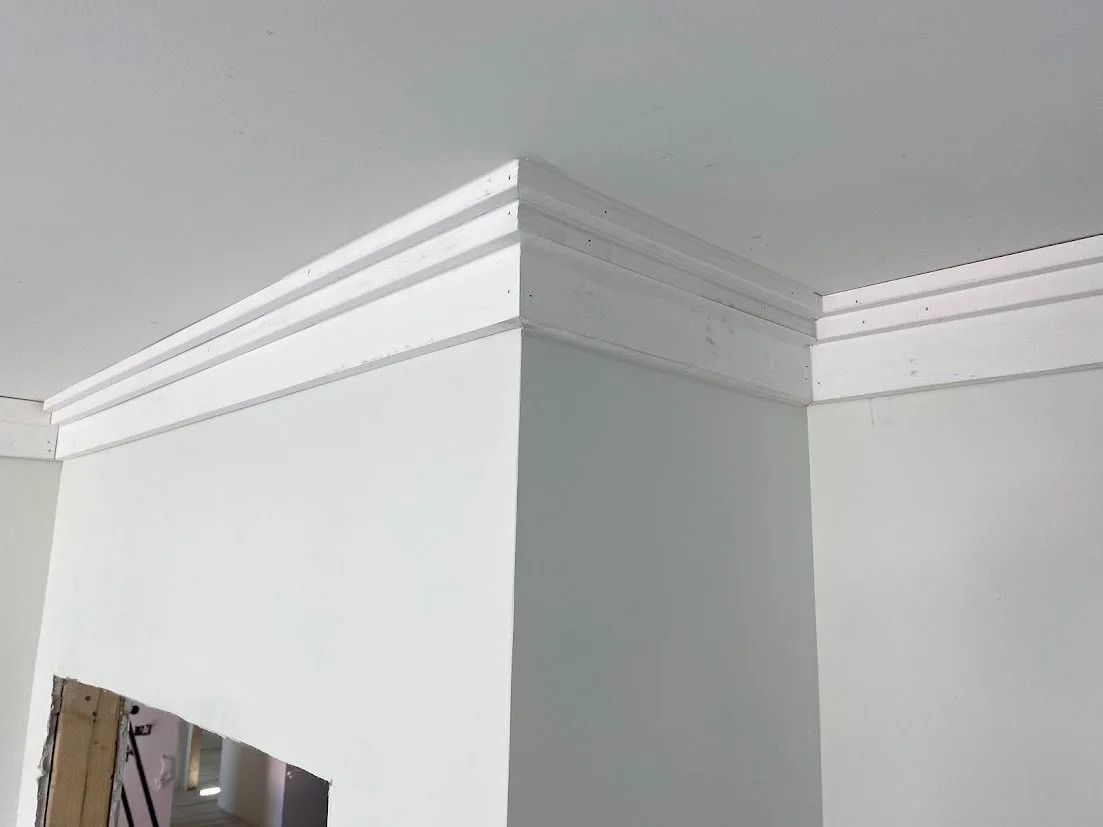 White crown molding installed in a corner where the ceiling meets the walls.