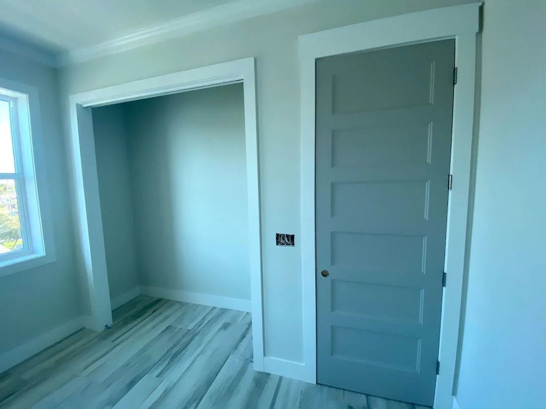 Room interior with gray door, white trim, and a closet.