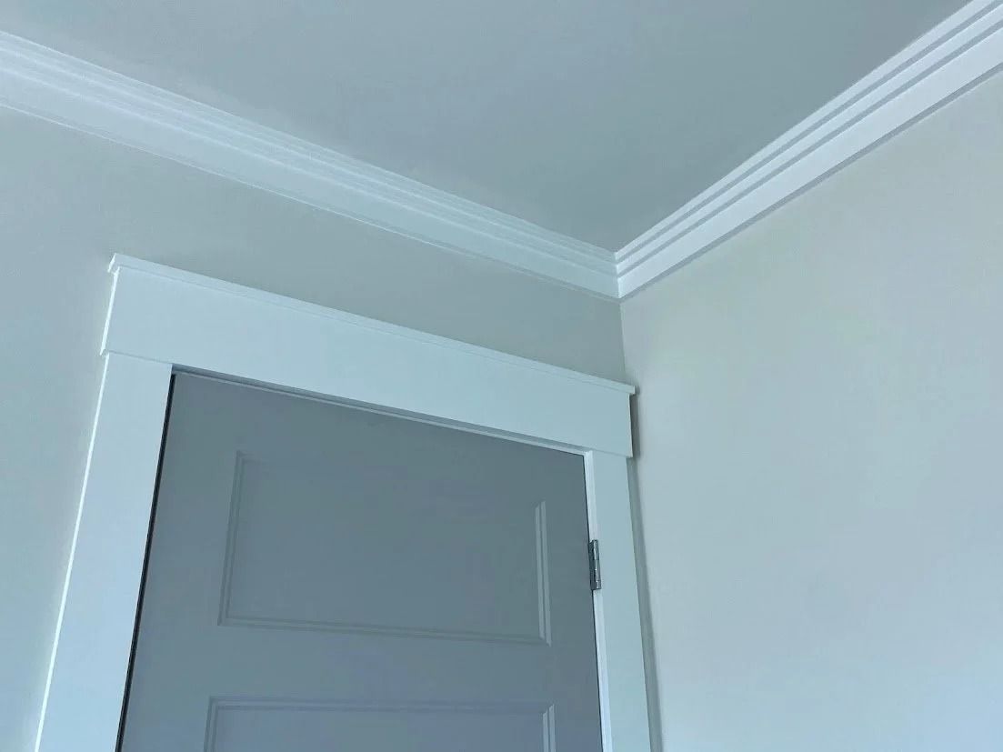 White door frame and crown molding against light gray walls.