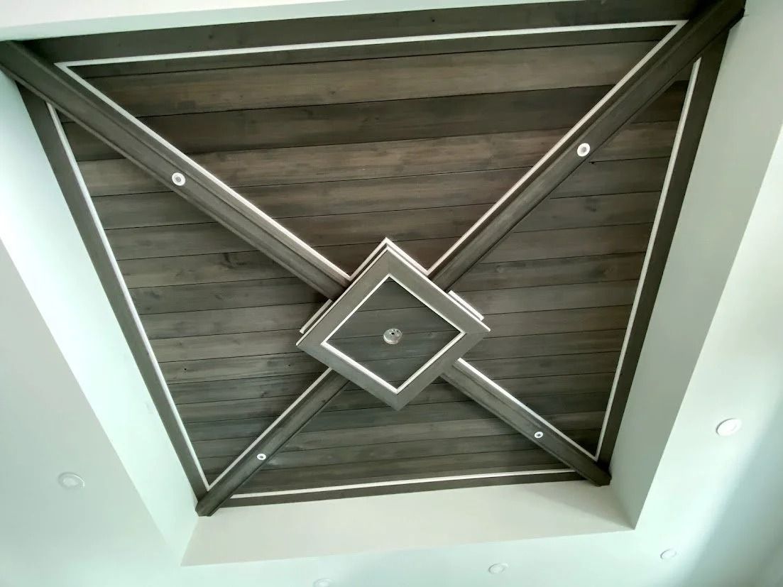 Dark wood paneled ceiling with gray trim and center square, angled design.