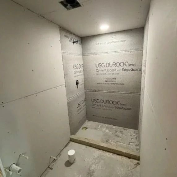 Bathroom under construction with gray cement board walls.