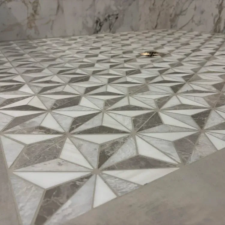 Gray tile installation in progress, spacers in grout lines, corner view.