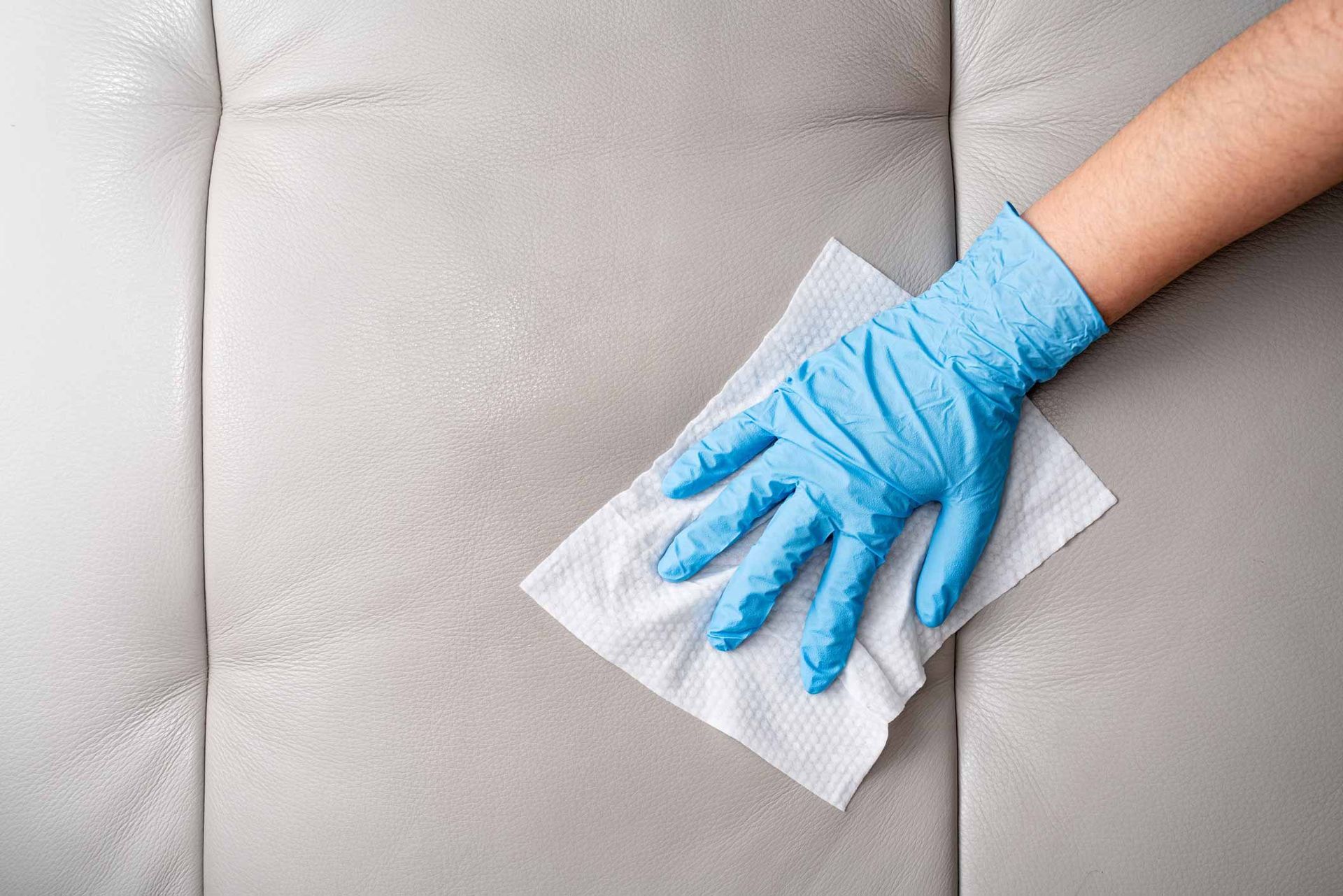 Hands With Glove Wiping Leather Sofa With Disinfection Wipes — Carson City, NV — Floor Masters