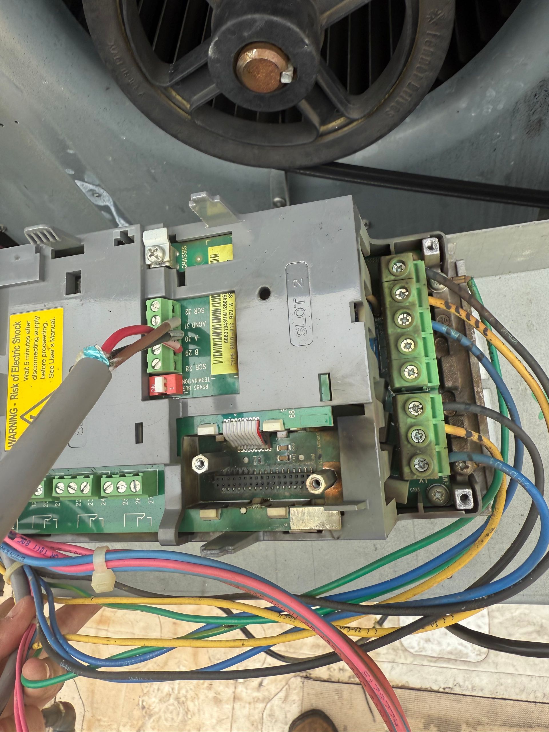 A damaged circuit board with burnt components and connected wires, likely from an electrical system.