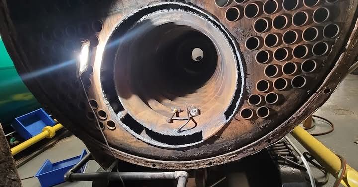 A close up of the inside of a boiler with holes in it.