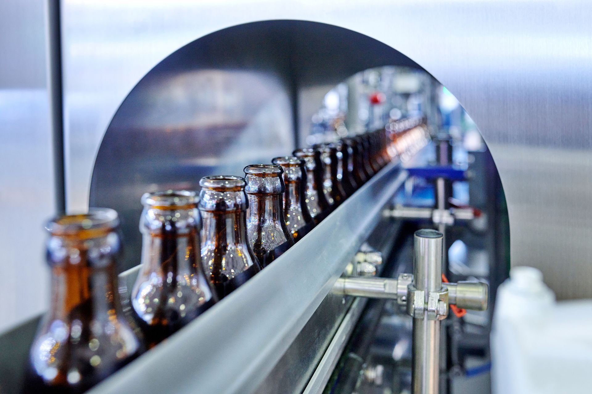 A conveyor belt filled with bottles in a factory.