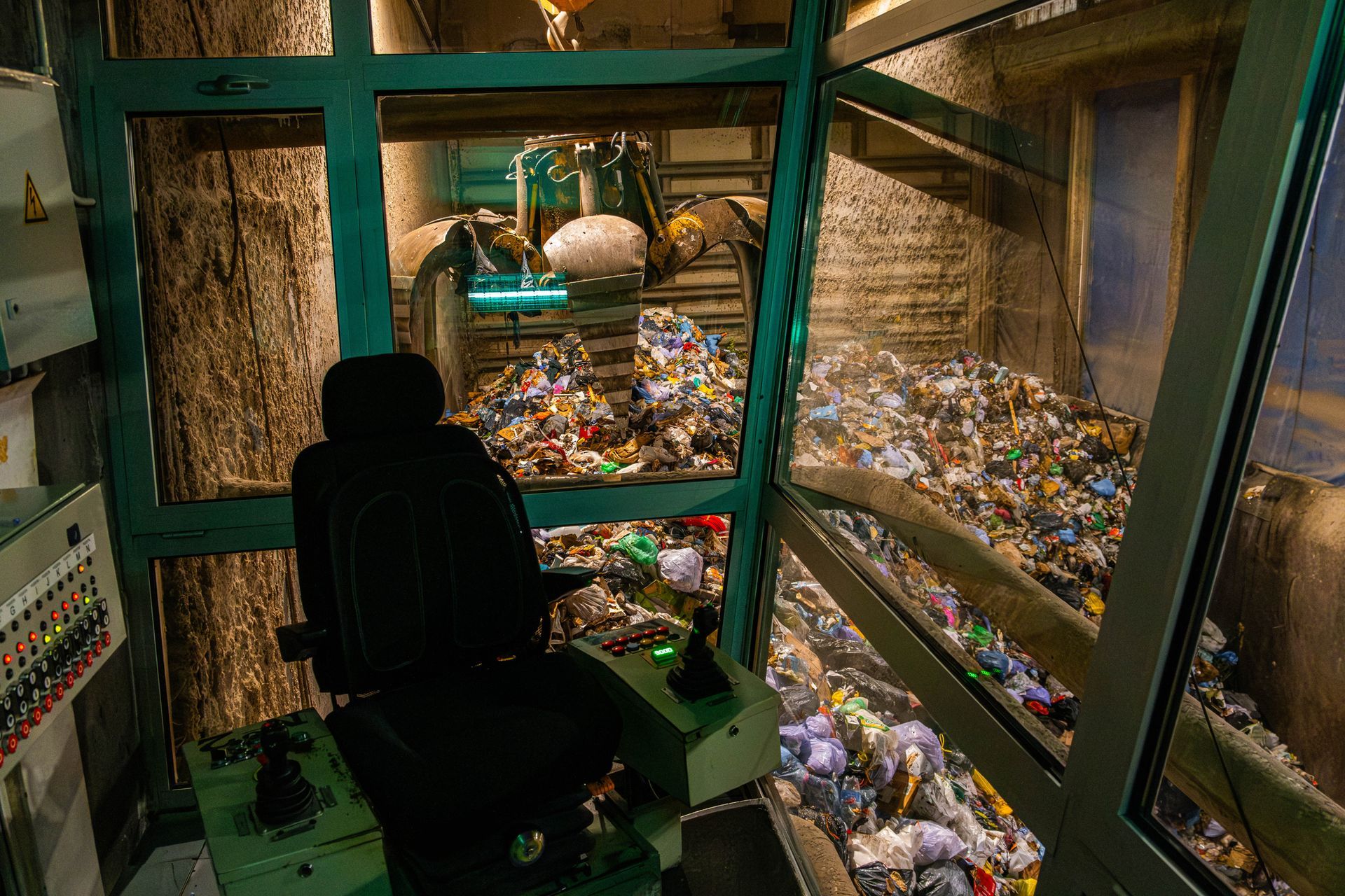 A man is driving a machine in a room filled with trash.