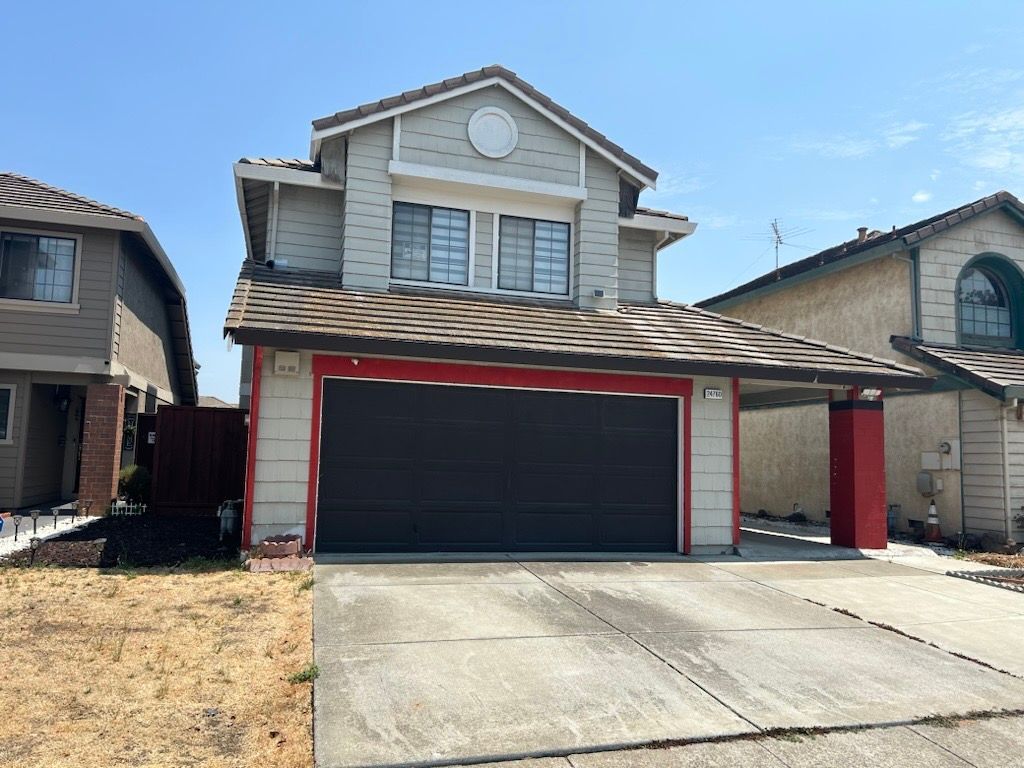 A two-story light gray house with a black double garage door, dark tiled roof, and bright red trim accents.