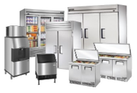 Commercial stainless-steel kitchen equipment, including refrigerators, prep tables, sinks, and storage cabinets