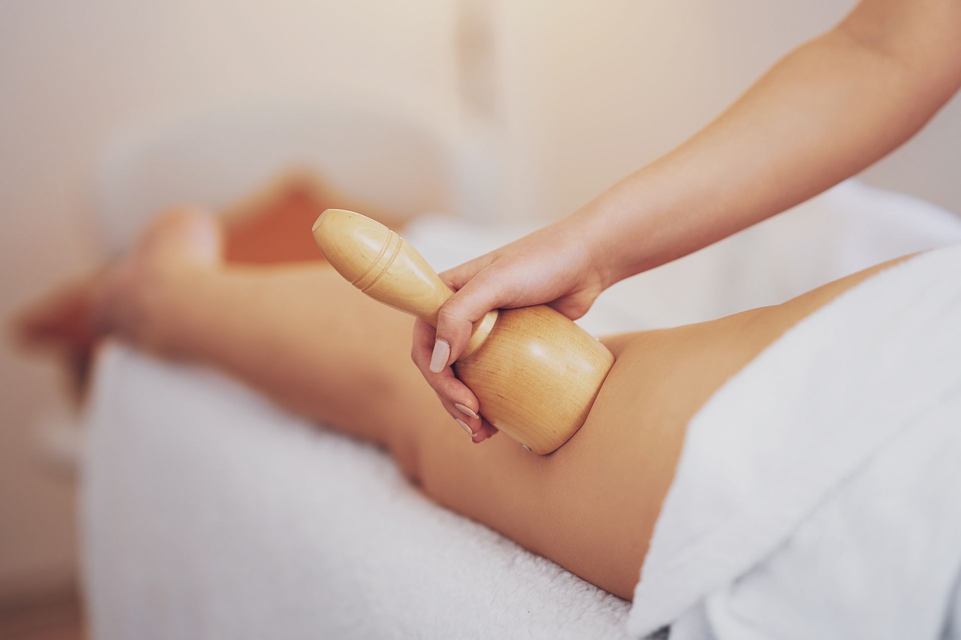 A woman is getting a massage with a wooden stick.