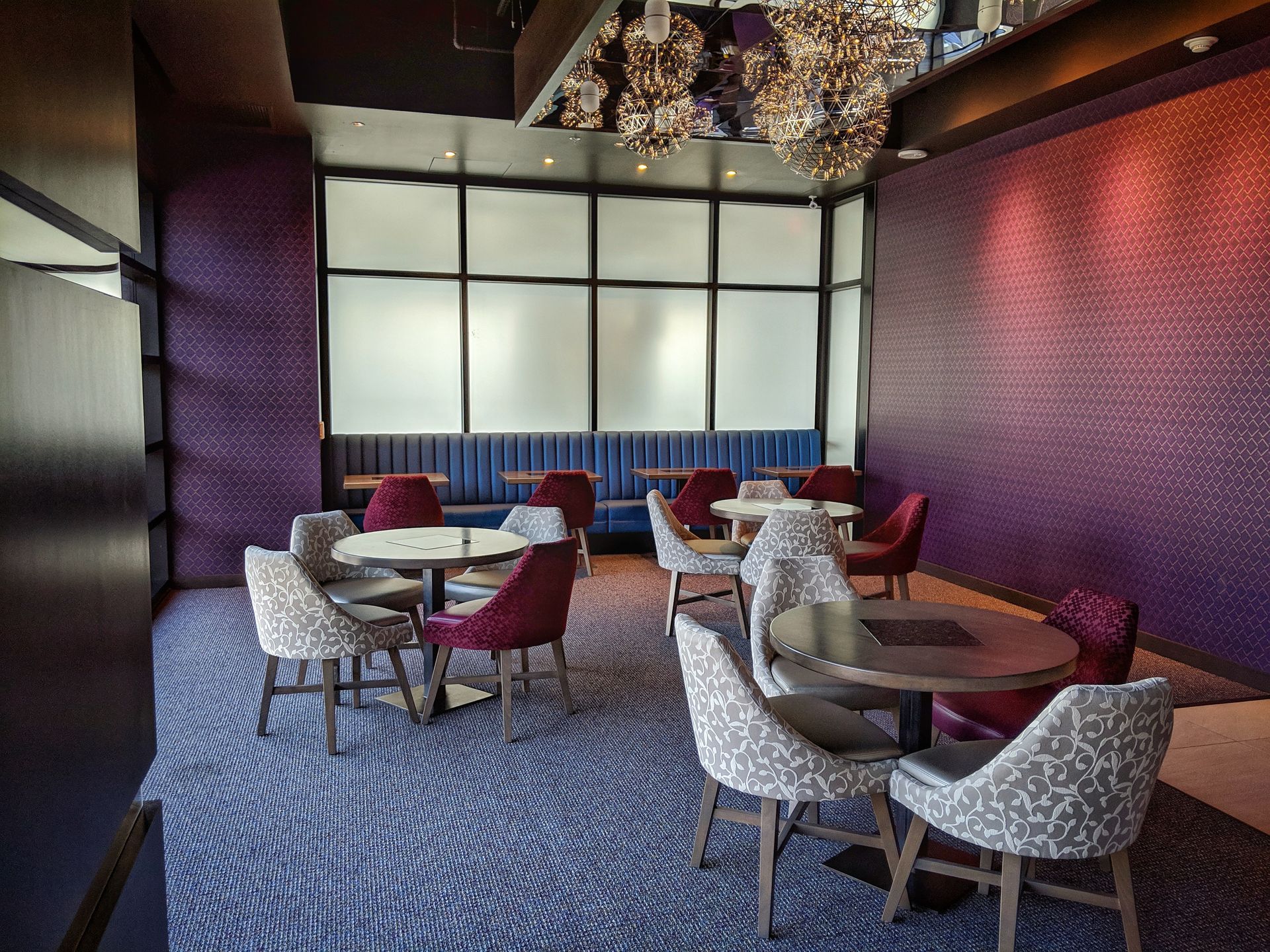 A restaurant with purple walls and tables and chairs