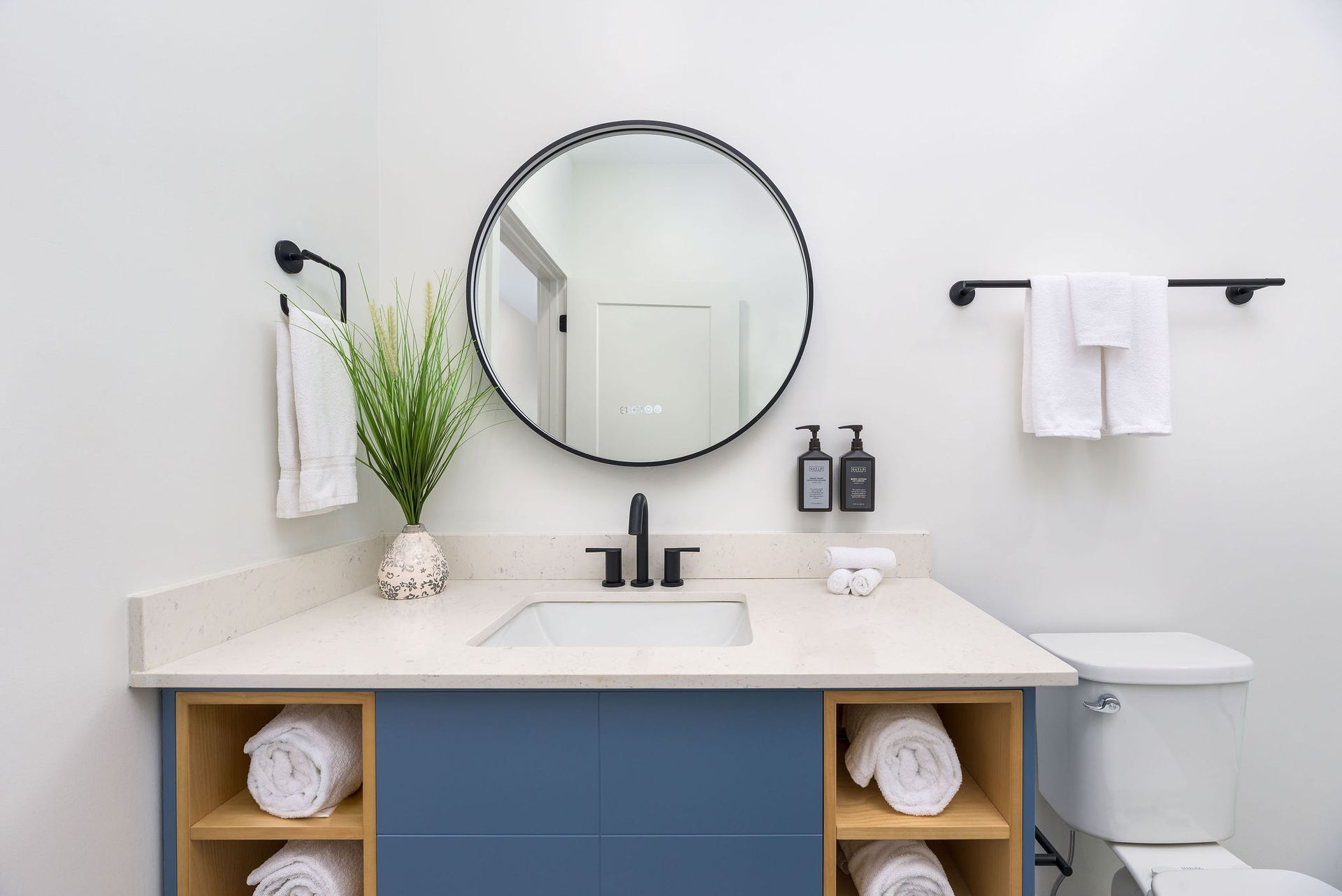 A bathroom with a sink , toilet and mirror.