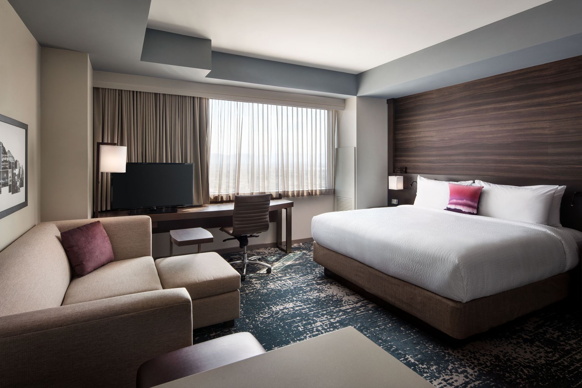 A hotel room with a king size bed and a couch