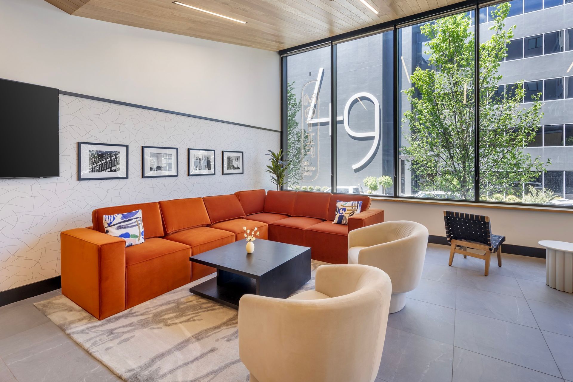 A living room with a couch , chairs , coffee table and television.