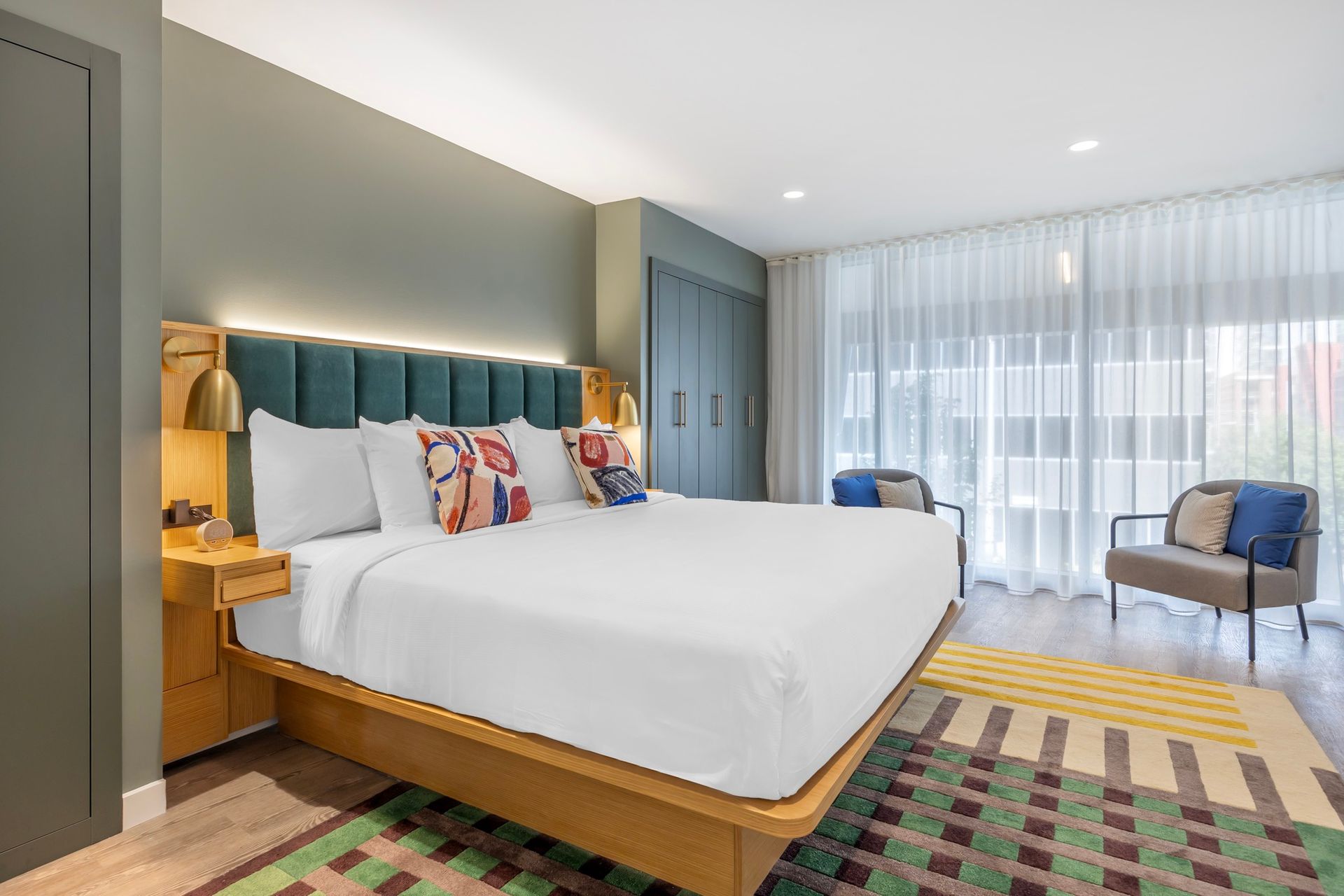 A hotel room with a king size bed and a chair.