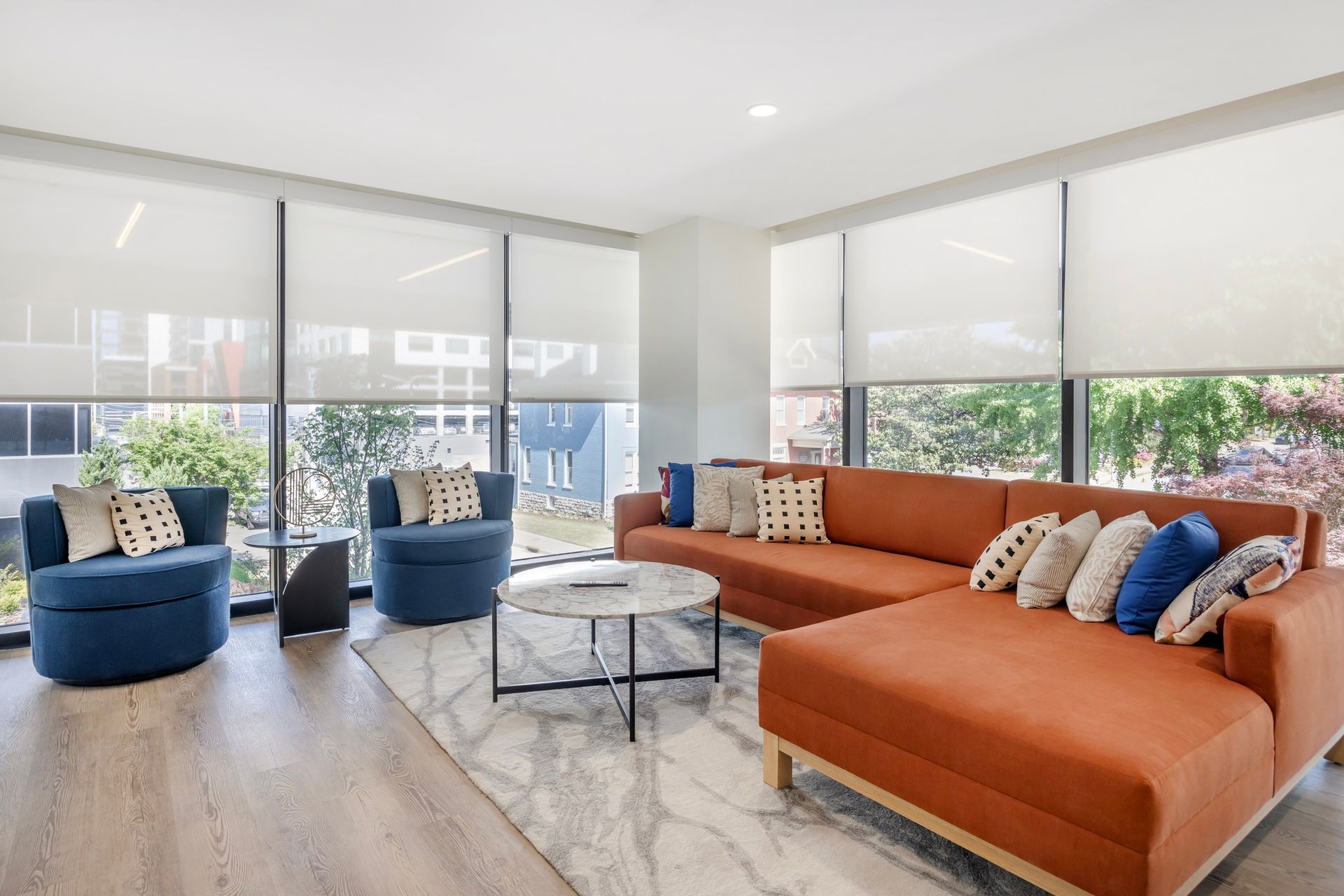 A living room with a couch , chairs , and a table.