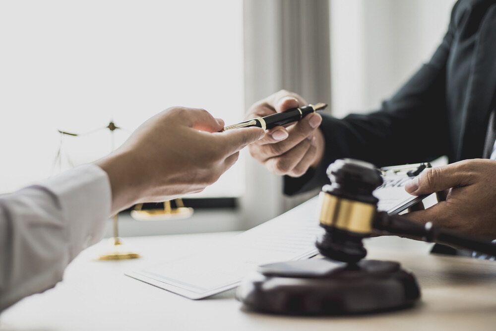 A Judge Is Giving A Pen To Another Judge — Spencer Lawyers In Gosford, NSW
