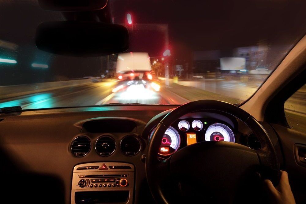 A Car Is Driving Down A Highway At Night — Spencer Lawyers In Gosford, NSW