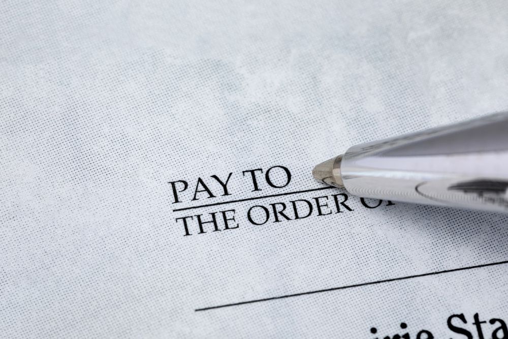 A Man In A Suit And Tie Is Wearing Handcuffs — Spencer Lawyers In Gosford, NSW