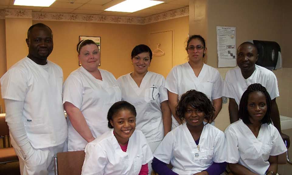 A group of people in white scrubs are posing for a picture