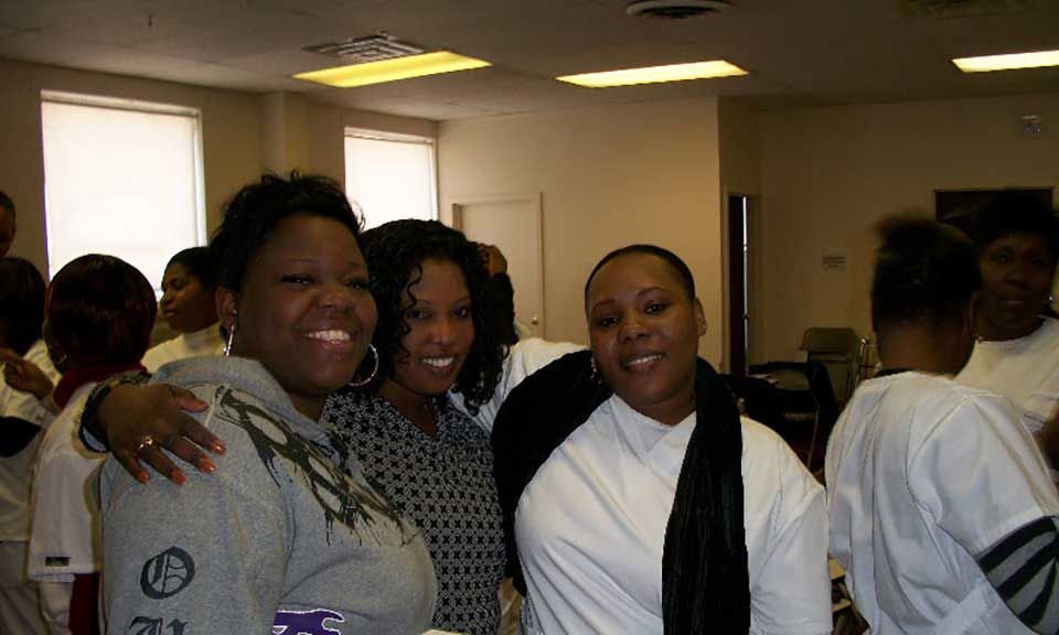 Three women are posing for a picture together in a room
