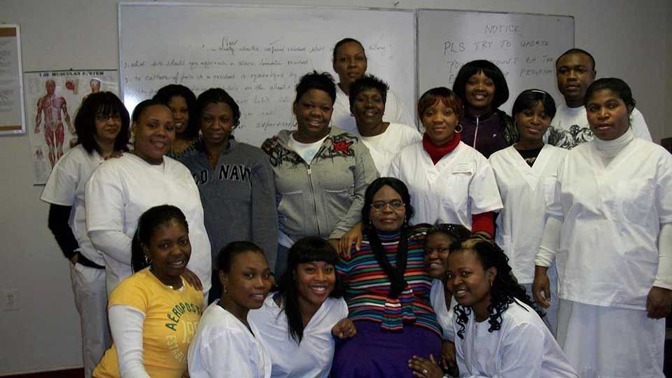 A group of people are posing for a picture in a classroom