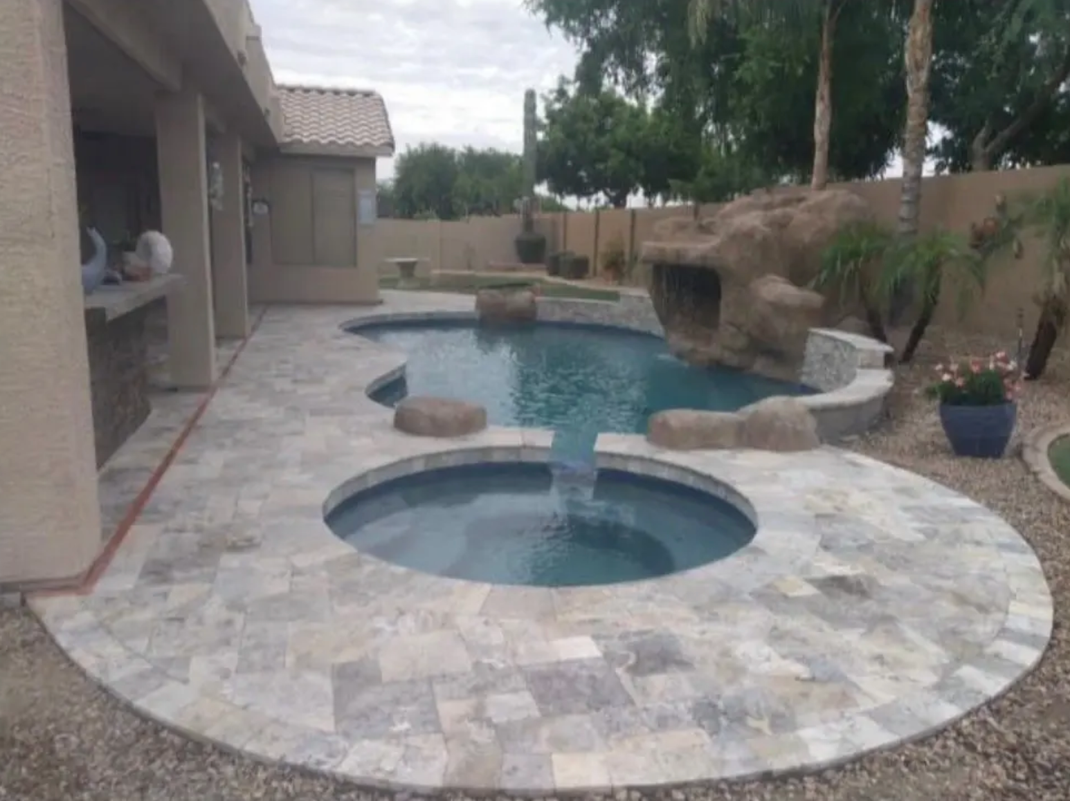 A large swimming pool with a hot tub in the middle of it.