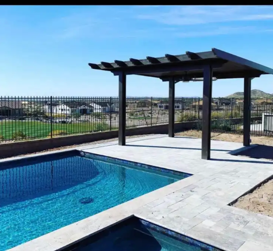 A large swimming pool with a pergola over it