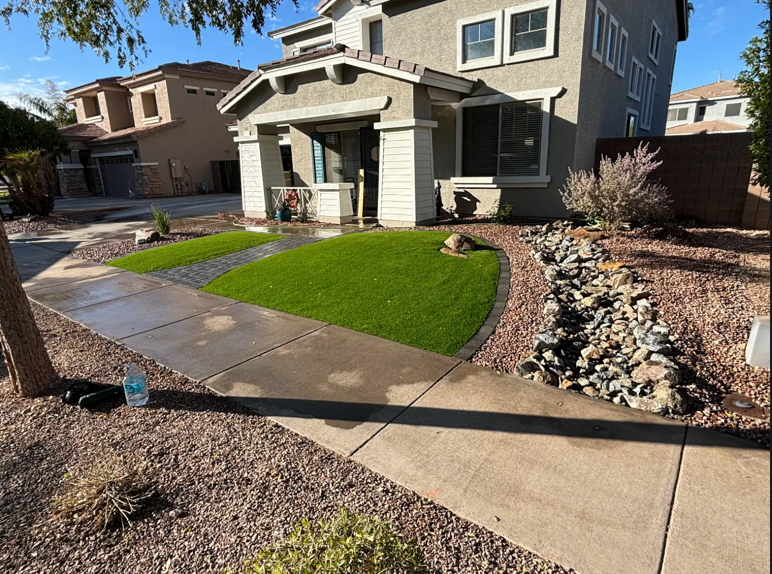 A house with a lush green lawn and a sidewalk in front of it.