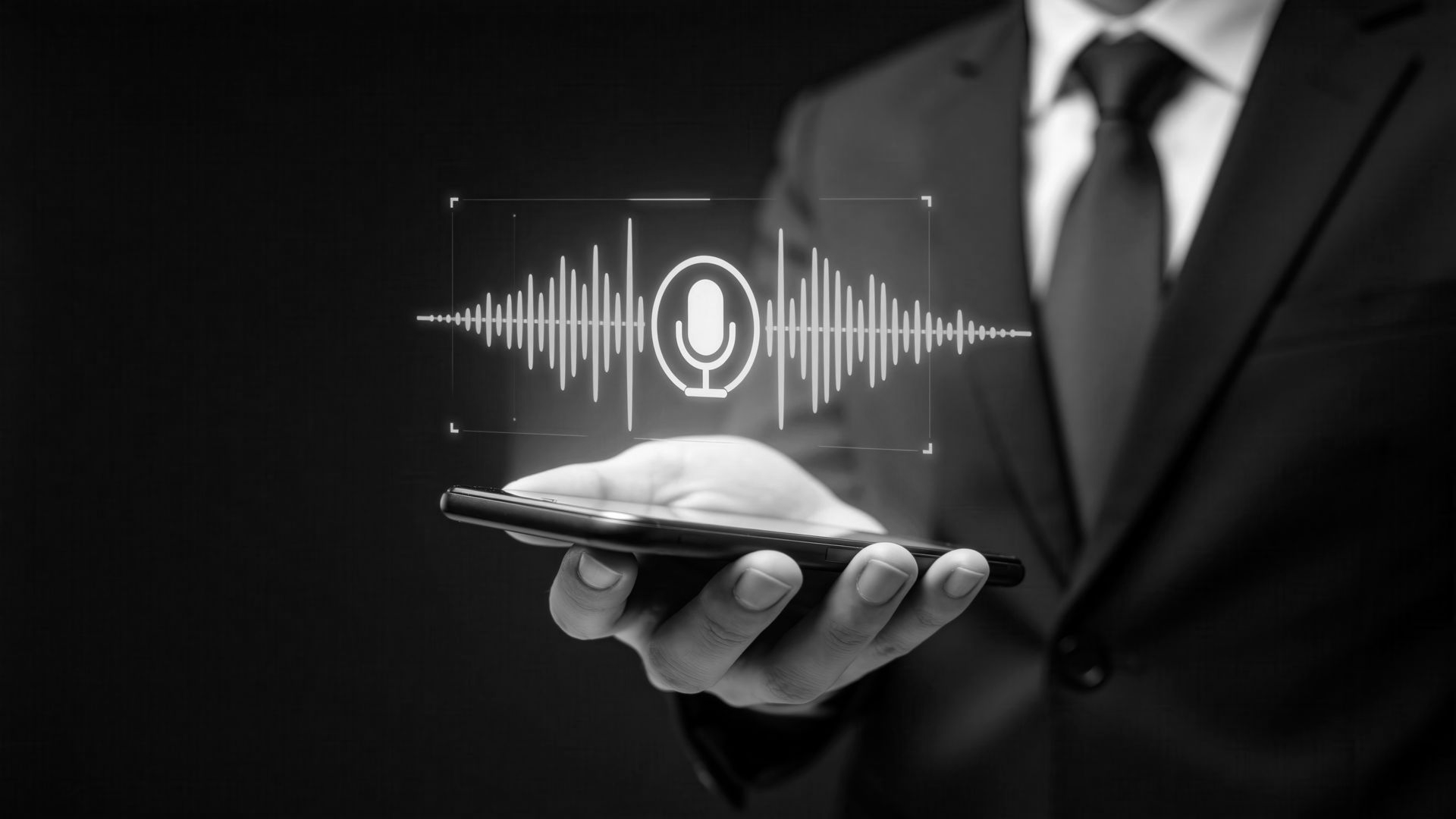 A person in a suit holds a smartphone, displaying a glowing, white digital audio waveform and microphone icon.