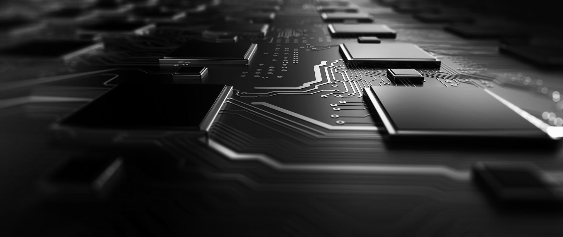 A close-up, monochromatic view of a computer circuit board with integrated chips and intricate pathways.