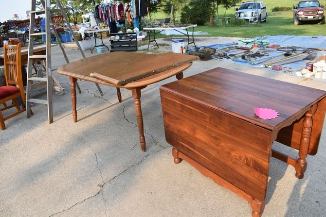 Two wooden tables are sitting on a concrete surface.