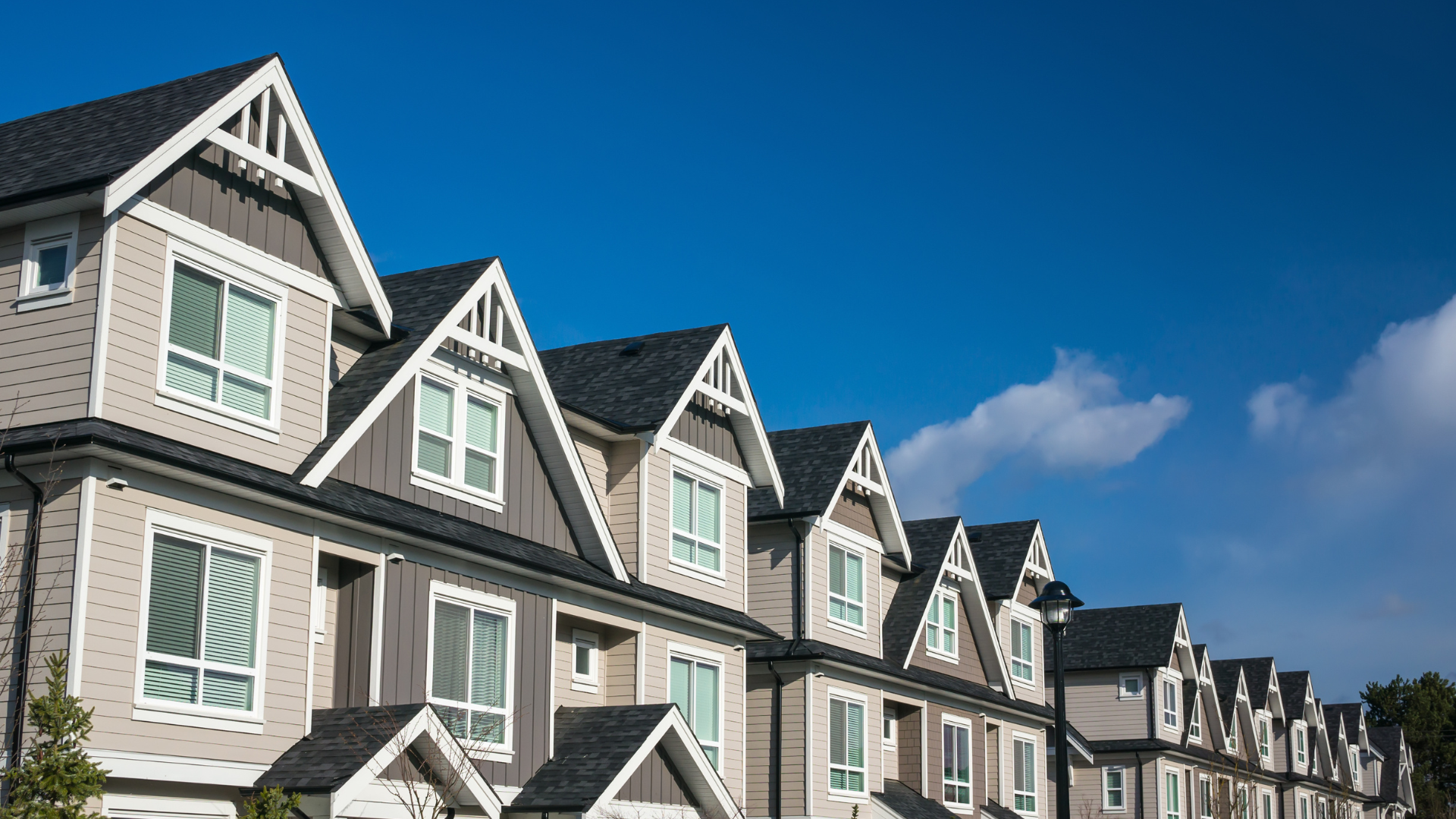 A row of houses with a blue sky in the background.