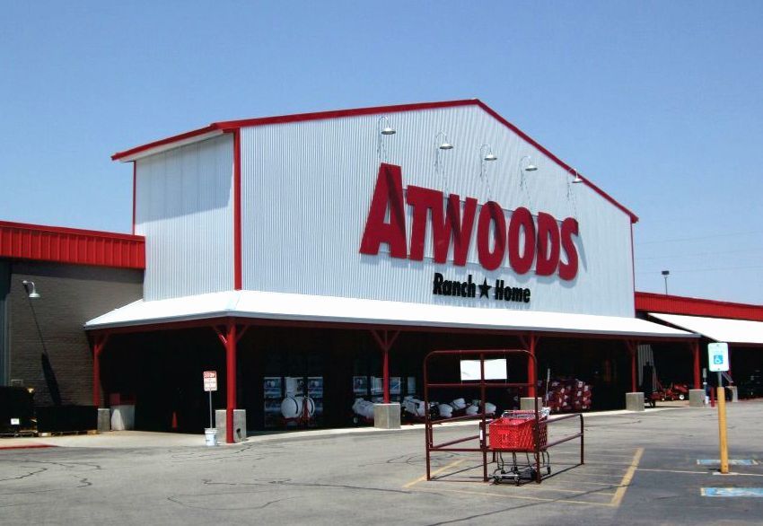 A shopping cart is parked in front of a store called atwoods