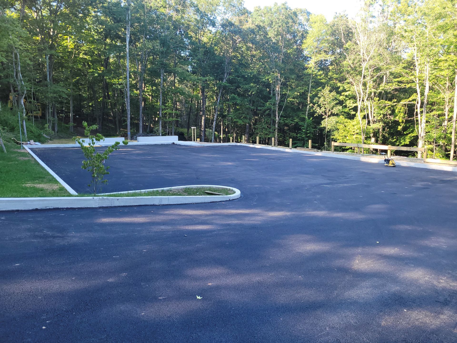 An empty parking lot with trees in the background