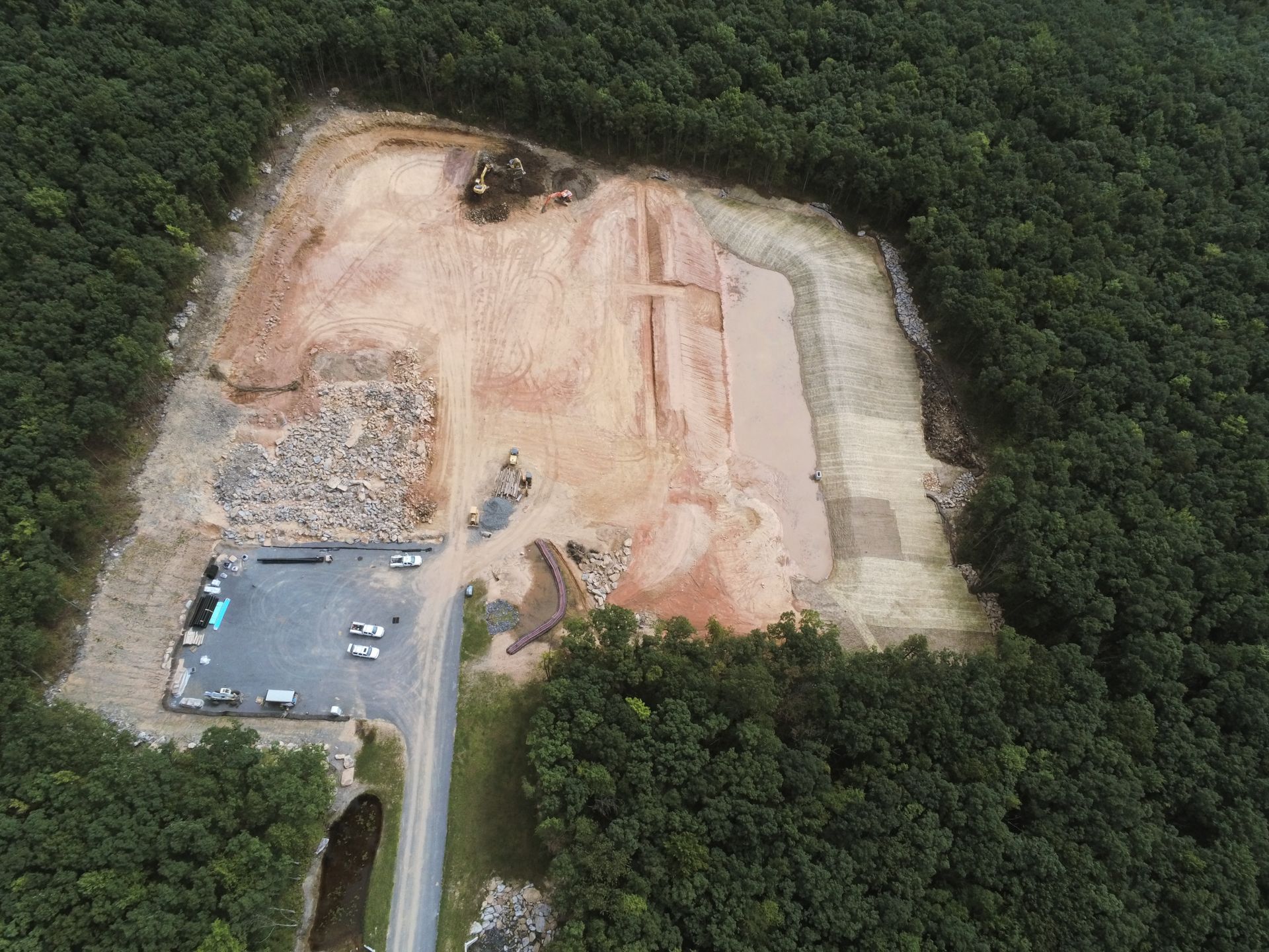 An aerial view of a construction site surrounded by trees.