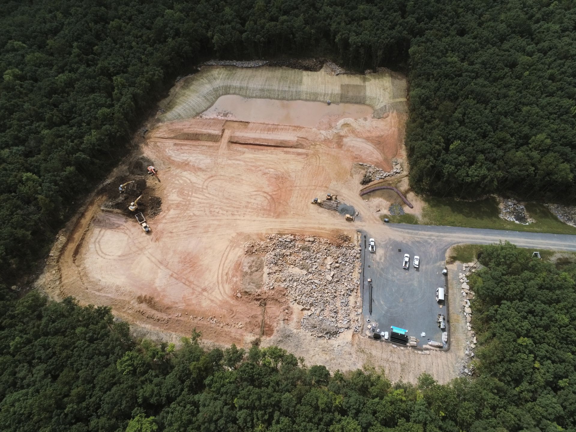 An aerial view of a construction site in the middle of a forest.