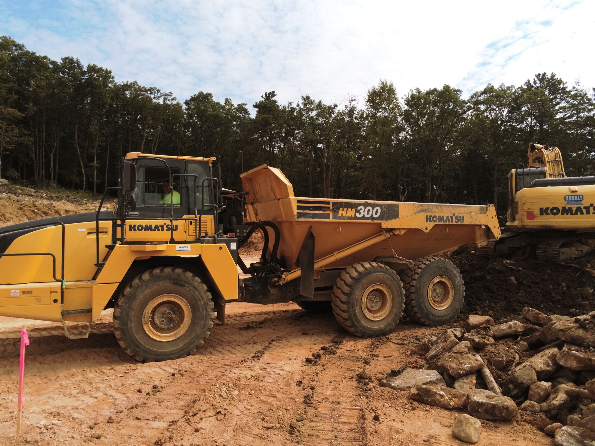 A komatsu dump truck is parked next to a komatsu excavator